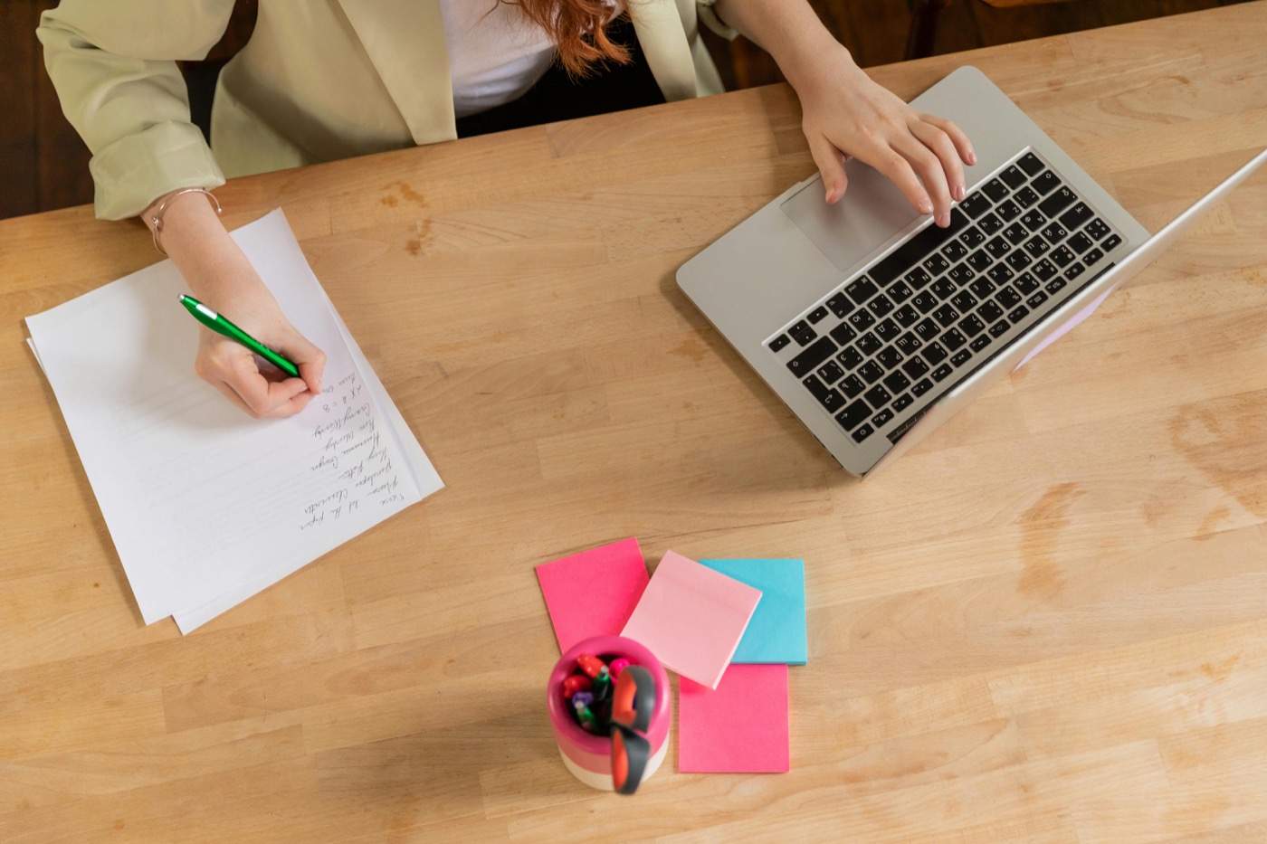 Academic folder and note planning represented by laptop and paper notes